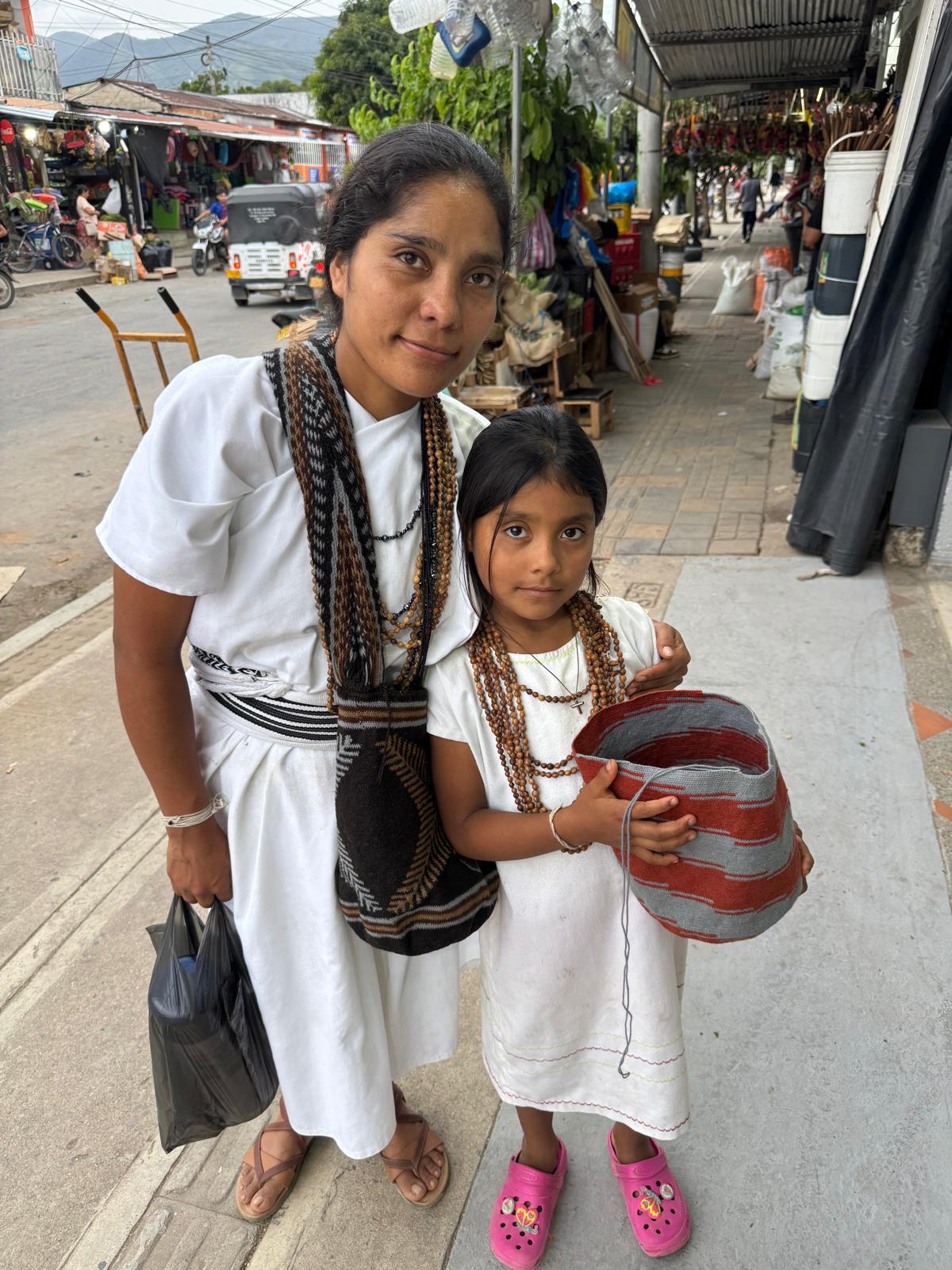 Mother and Daughter: the girl was weaving a bag while walking on the streets